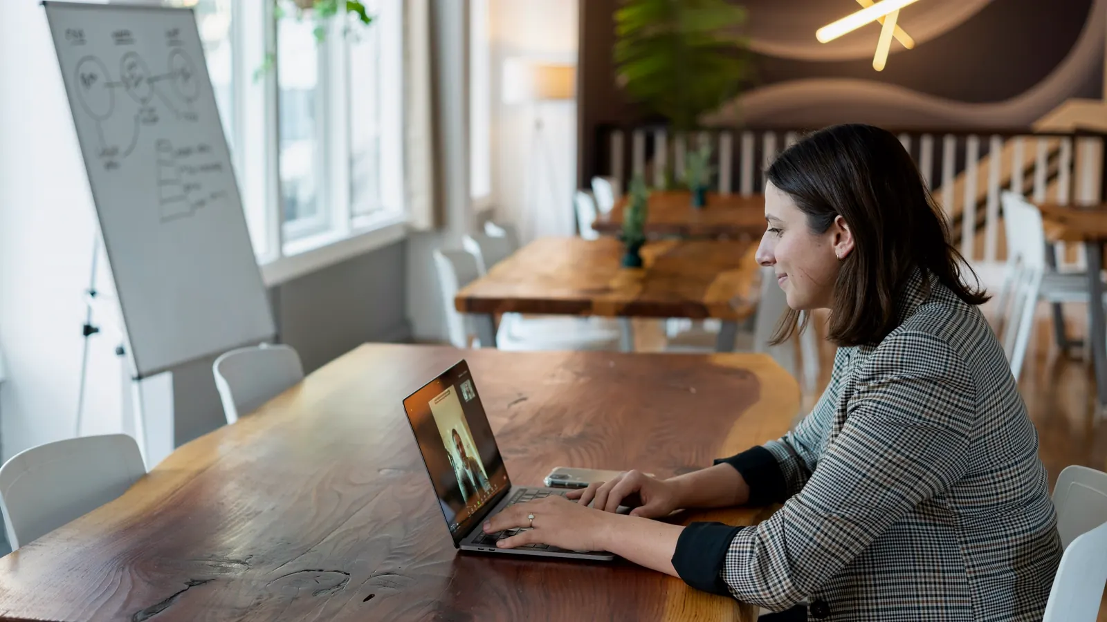 A team member working on a laptop in a bright meeting room